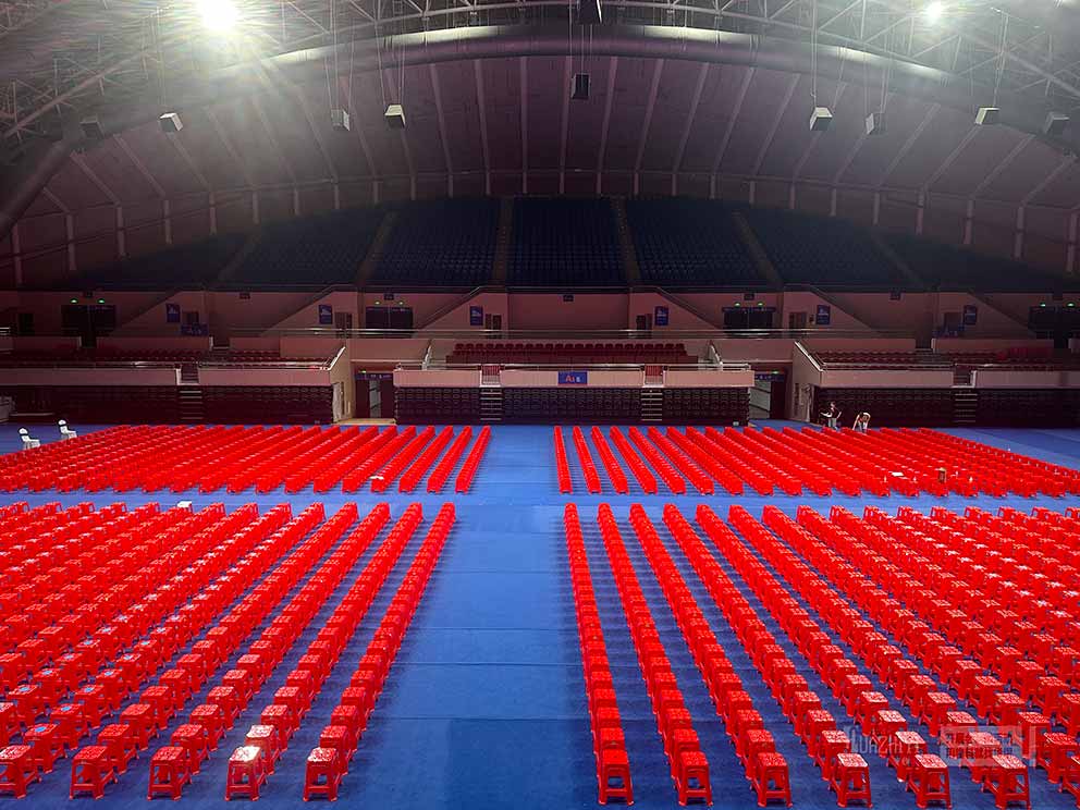 鄭州桌椅出租廠家布置臨時會場現(xiàn)場，紅色塑料凳整齊劃一